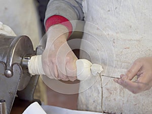 Traditional pork salami making using pig intestines for skin. Rustic, rural Italy. Genuine farm production.