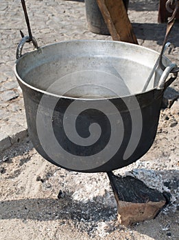 Traditional pot over fire and steam coming from it, authentic medieval cuisine