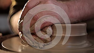 Traditional pottery making, close up of potter`s hands shaping a bowl on the spinning by clay