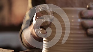 Traditional pottery making, close up of potter`s hands shaping a bowl on the spinning by clay