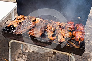 Traditional Poulet Boucane smoked chicken and ribs cooking in BBQ barrel in Martinique photo