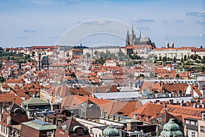 Traditional Prague roofs with famous gothic and medieval city towers with St. Vitus in the background, Czechia