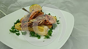 Traditional prawn with garlic and yuca as top view served in a white dish. Caribbean food concept. Close up view