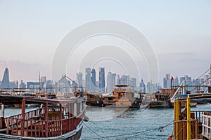 Traditional Qatari dhow boats with the skyline of Doha West Bay skyscrapers