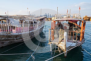 Traditional Qatari dhow boats with the skyline of Doha West Bay skyscrapers