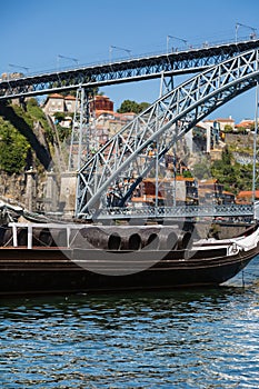 Traditional Rabelo Boats on the Bank of the River Douro and Dom Luis I Bridge in background - Porto, Portugal