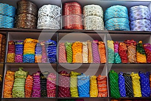 Traditional Rajasthan dress materials for sale in a cloth merchant shop in India. Colorful Jodhpur fabric street stall. Bandhej or