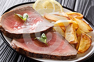 Traditional recipe of beef steak is served with roasted potatoes