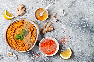 Traditional red lentil Dal. Indian Dhal spicy curry in bowl with flat bread and spices. Top view, overhead.