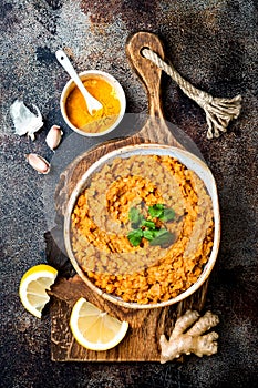 Traditional red lentil Dal. Indian Dhal spicy curry in bowl with flat bread and spices. Top view, overhead.