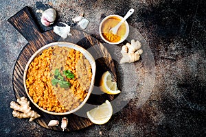 Traditional red lentil Dal. Indian Dhal spicy curry in bowl with flat bread and spices. Top view, overhead.