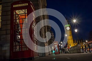 Traditional red phone booth or telephone box with the Big Ben in the background, possible the most famous English landmark, at