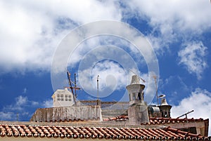 A traditional red tile rooftop with chimneys in a portuguese town