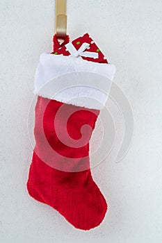 Traditional red and white plush Christmas stocking stuffed with a wrapped present