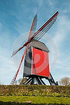 Traditional red wooden windmill against blue sky