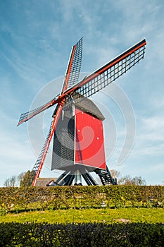 Traditional red wooden windmill against blue sky