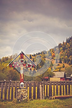Traditional religious cross symbol with autumn scenery background in Bucovina
