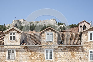 Traditional residential architecture with dormer windows below castle on hill Croatia