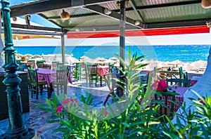Traditional restaurant outdoor seating overlooking beach Kamari Santorini Greece