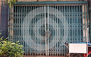 Traditional retractable metal grill at a shophouse