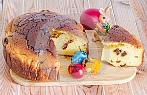 Traditional romanian cake called Pasca with colored easter eggs, bunny, wood background.