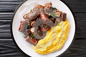 Traditional romanian dish pomana porcului assortment of pork meat, sausages with mamaliga close-up in a plate. Horizontal top view