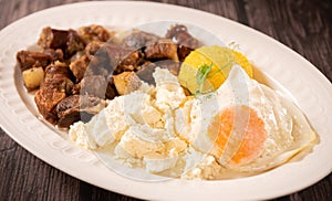 Traditional Romanian food called tochitura made of fried eggs, polenta and pork meat