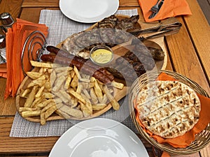 Traditional Romanian food platter with mici, sausages, fries and bread