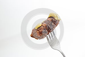 Traditional Romanian grilled minced meat, mici or mititei on a metal fork