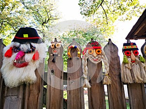 Traditional romanian masks on wooden fence