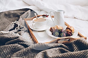 Traditional romantic breakfast in bed in white and beige bedroom