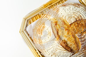 Traditional round loaf of bread baked according to a classic recipe, served on a wicker basket