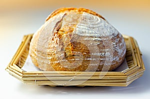 Traditional round loaf of bread baked according to a classic recipe, served on a wicker basket