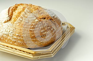 Traditional round loaf of bread baked according to a classic recipe, served on a wicker tray