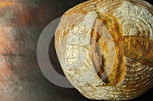 Traditional round loaf of bread baked according to a classic recipe, served on a wooden board