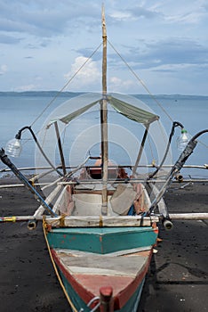 Traditional rowboat on a volcanic beach at Tabaco in the Philippines photo