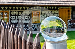 Traditional rural cottage through lens ball. Village CIcmany, Slovakia