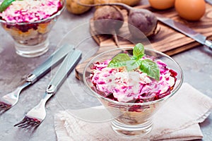 Traditional Russian appetizer of boiled vegetables and fish - herring under a fur coat in bowls and ingredients for cooking