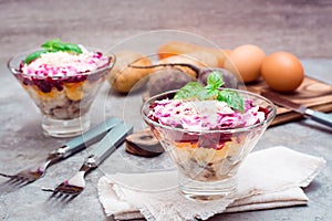 Traditional Russian appetizer of boiled vegetables and fish - herring under a fur coat in bowls and ingredients for cooking