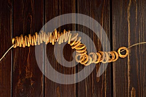 Traditional russian bagels on a rope on dark wooden table, top view