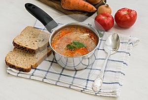 Traditional russian cabbage soup shchi in a ladle on a white background