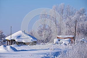Traditional russian country house izba in village Talitsa under winter snow photo