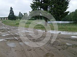 Traditional Russian countryside landscape with dirty Russian roads. Puddles, dirt, bumps and bumps.