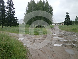 Traditional Russian countryside landscape with dirty Russian roads. Puddles, dirt, bumps and bumps.