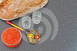 Traditional russian food. Red caviar in a glass bowl and fresh baked bread.