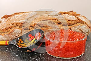 Traditional russian food - red caviar. Wooden spoon painted in traditional style Khokhloma.