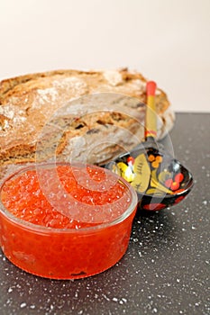 Traditional russian food - red caviar. Wooden spoon painted in traditional style Khokhloma.