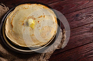 Traditional Russian homemade pancakes on a large round plate in a rustic style