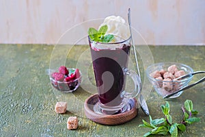 Traditional Russian hot or cold drink, blueberry jelly or kissel in a glass mug on a green concrete background