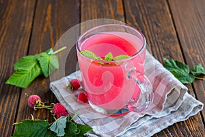 Traditional Russian hot drink raspberry jelly or kissel in a glass transparent mug on a brown wooden background